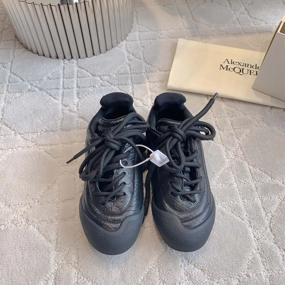 Close-up of black leather and embossed logo on Alexander Mcqueen sneaker