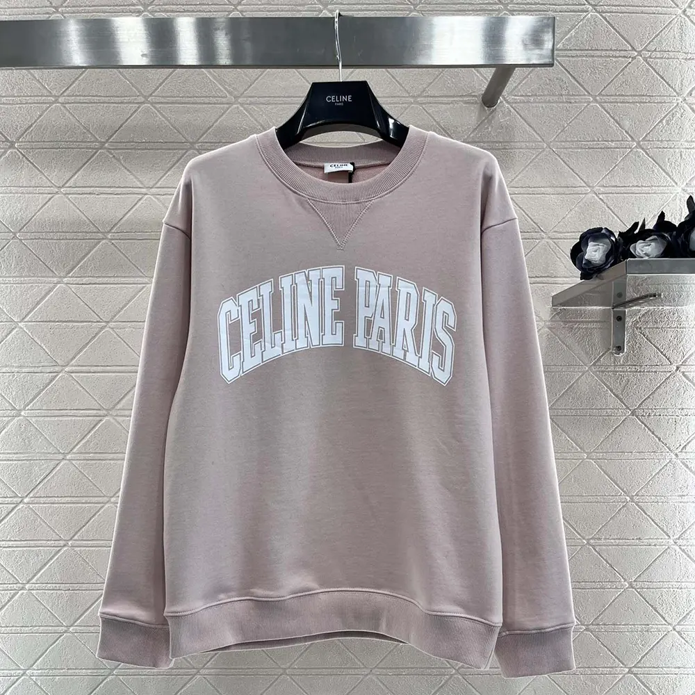 Close-up of embossed Celine logo detail on pink oversized sweatshirt