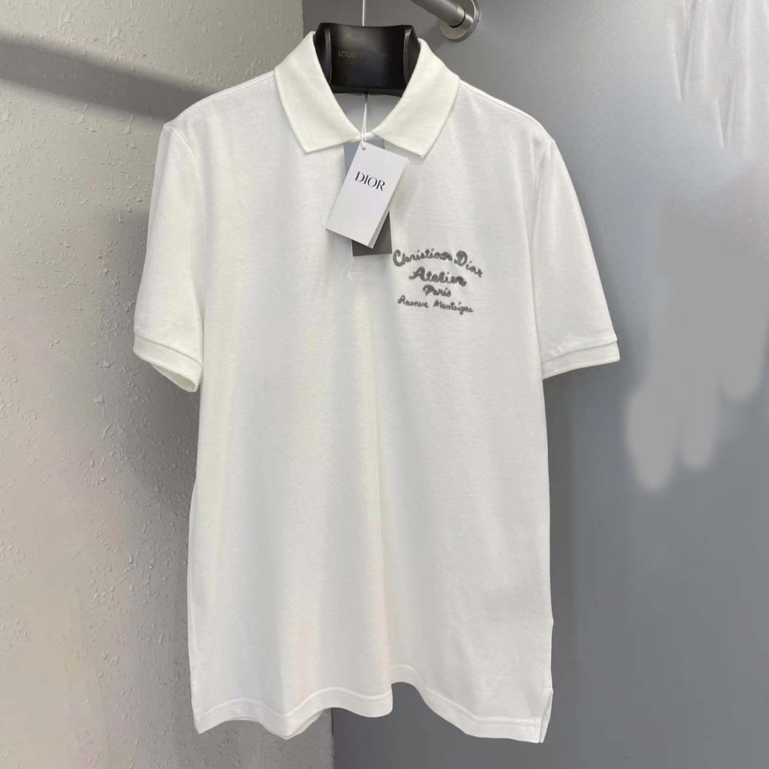 Close-up of Dior logo embroidery on white cotton polo shirt