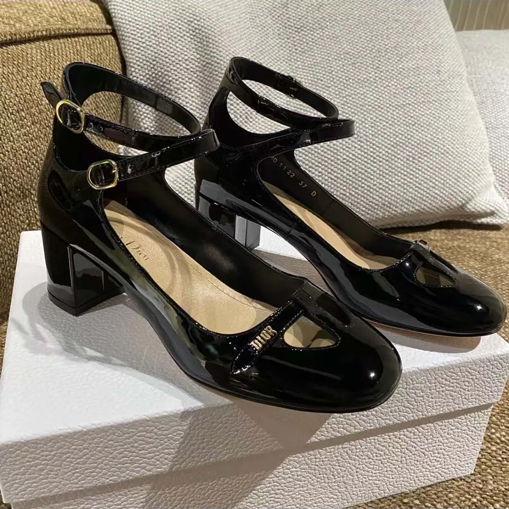 Close-up on signature Dior hardware detail on black patent pump