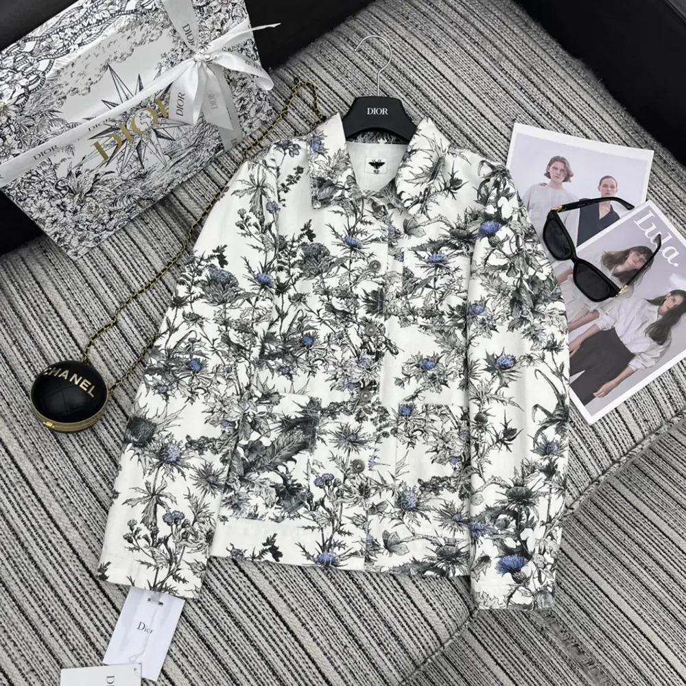 Close-up detail of blue Dior Chardons embroidery on white denim jacket