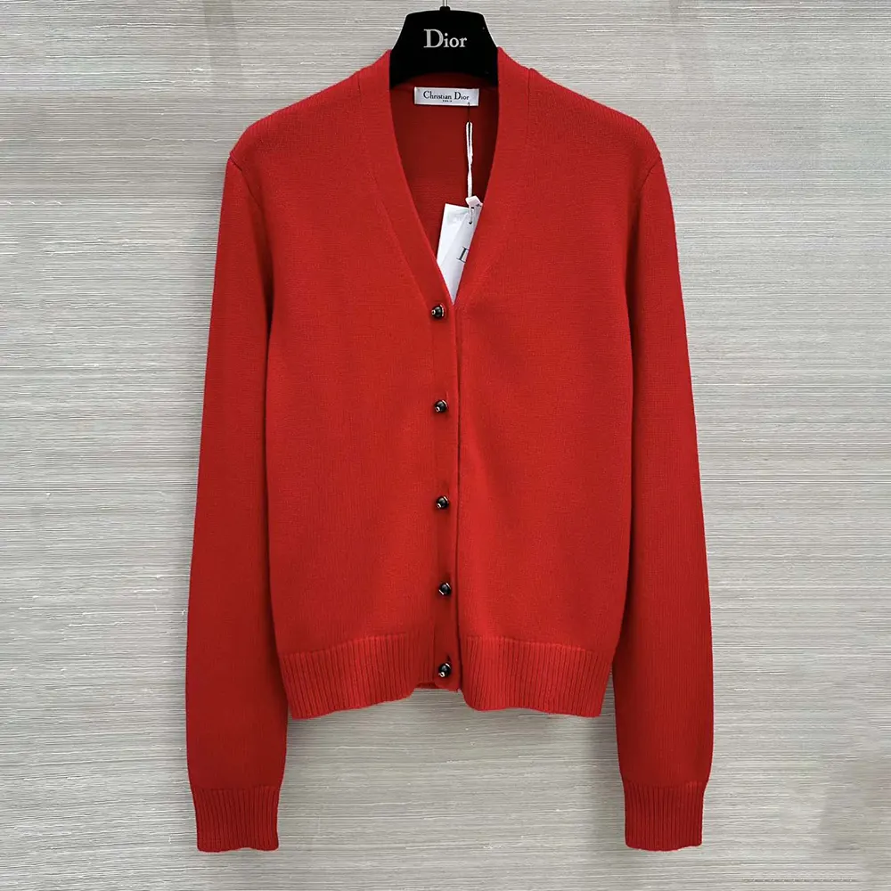 Close-up of signature Dior buttons on red cashmere twinset