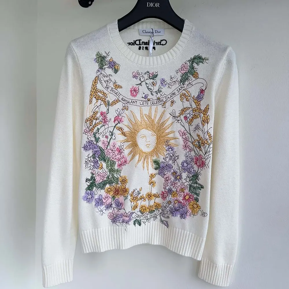 Close-up of multicolor Dior 4 Saisons Été embroidery detail on white cashmere sweater