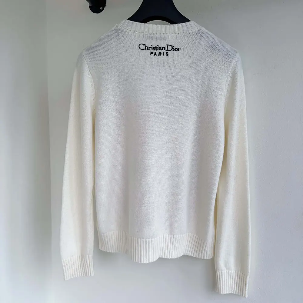 Side angle showing relaxed fit of Dior Women Embroidered Sweater in white cashmere
