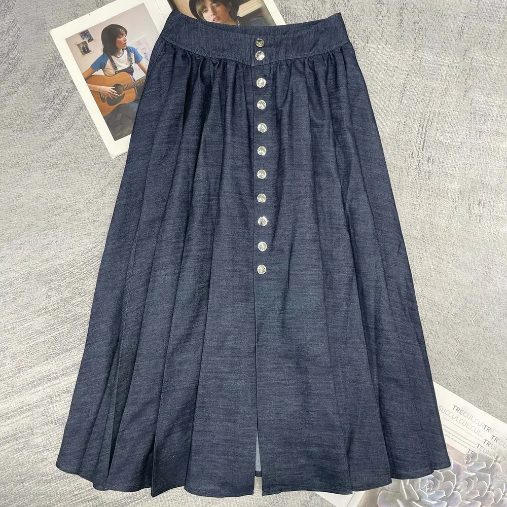 Close-up of signature snap button closure on Dior navy denim skirt
