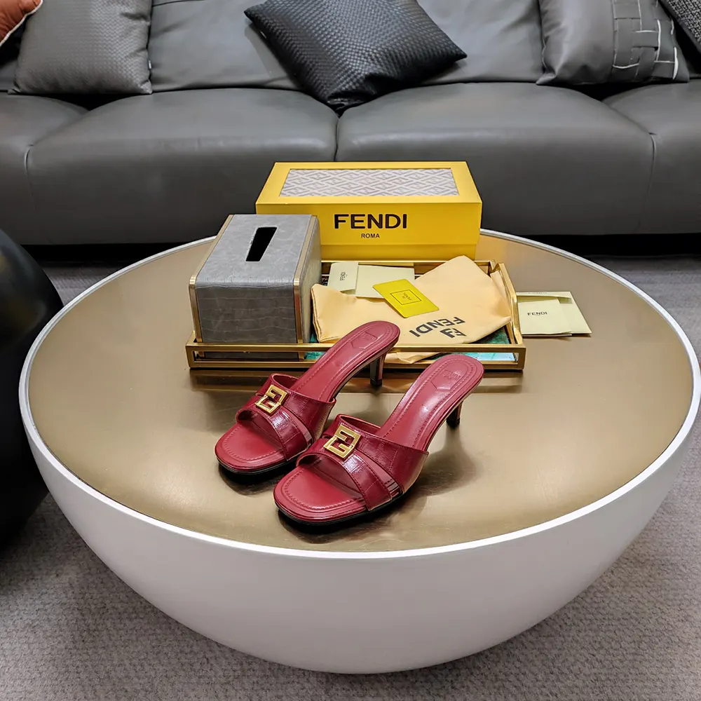 Close-up on gold-tone FF logo hardware on Fendi sandals