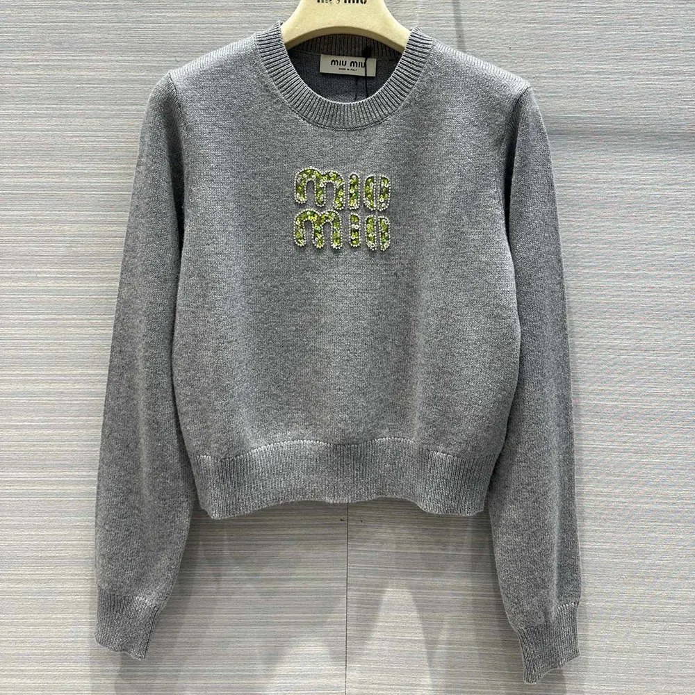 Close-up detail of Miu Miu logo embroidery on cashmere sweater