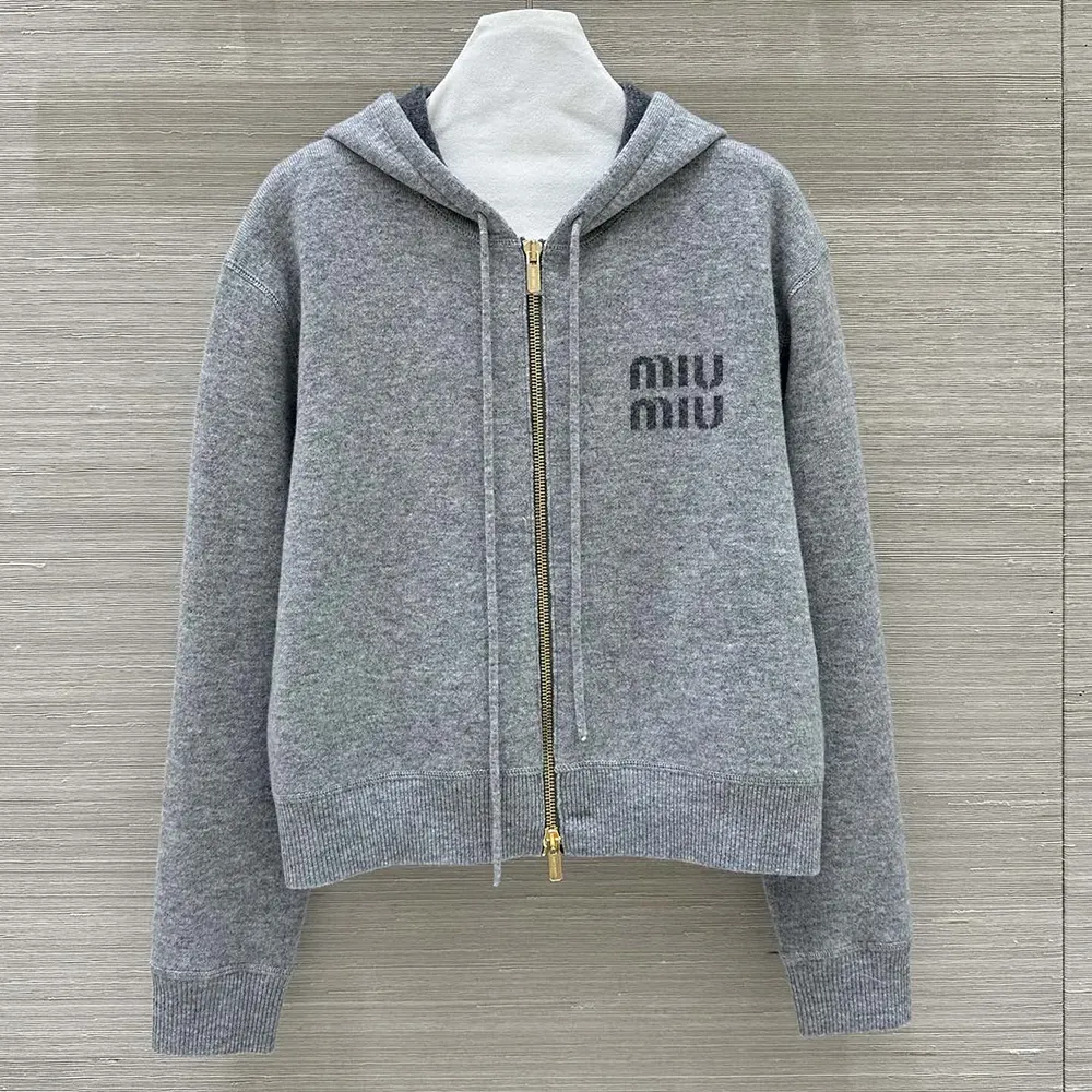 Close-up of silver zipper and branded hardware on Miu Miu cashmere cardigan