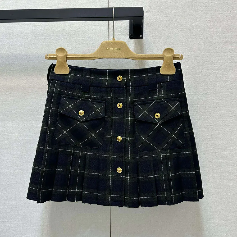 Close-up on pleated detail and tartan pattern of Miu Miu miniskirt