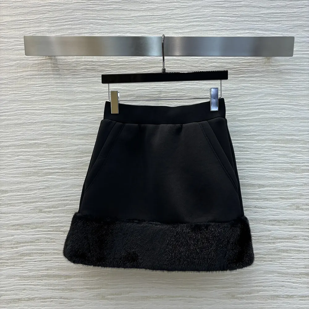 Close-up of Prada logo detail on black sweatskirt fabric