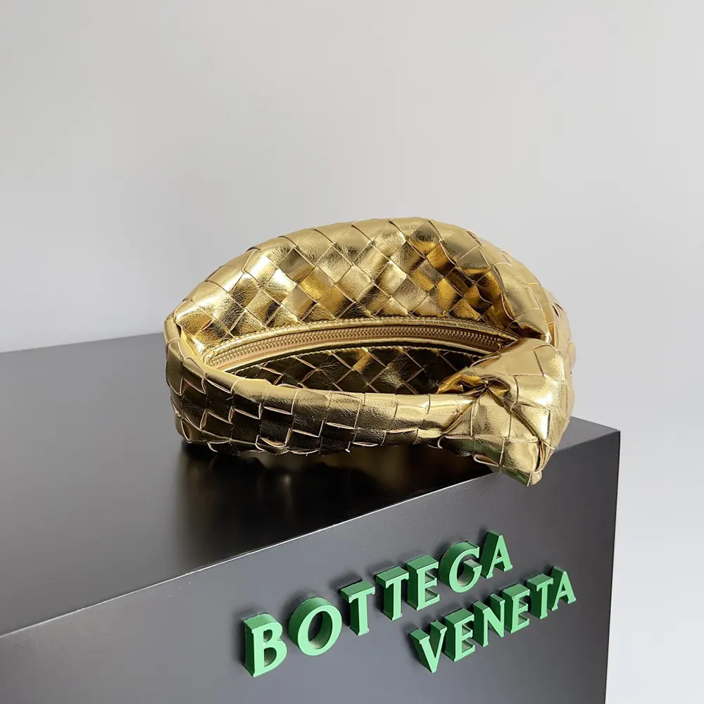 Side angle showing gold flap closure of Bottega Veneta Women Mini Jodie-Gold