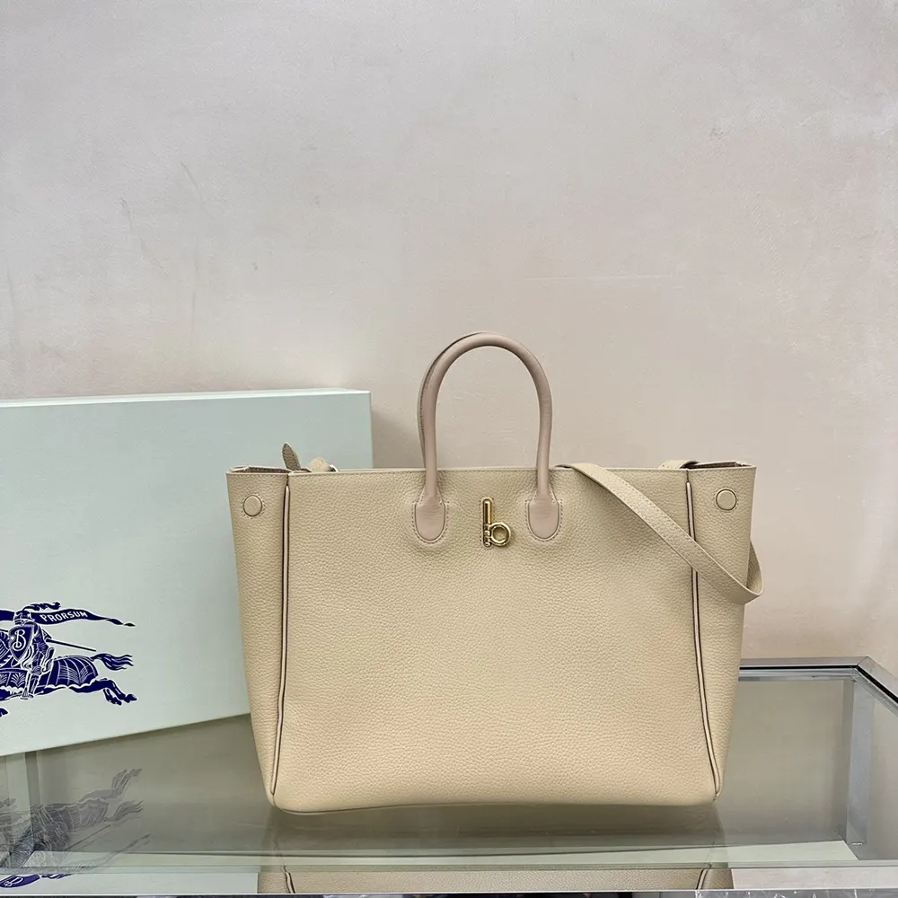 Close-up of polished gold-tone hardware on Burberry Women Medium Rocking Horse Tote​-Sandy