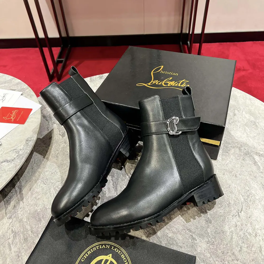 Front angled view showing sleek silhouette of Christian Louboutin black Chelsea boots