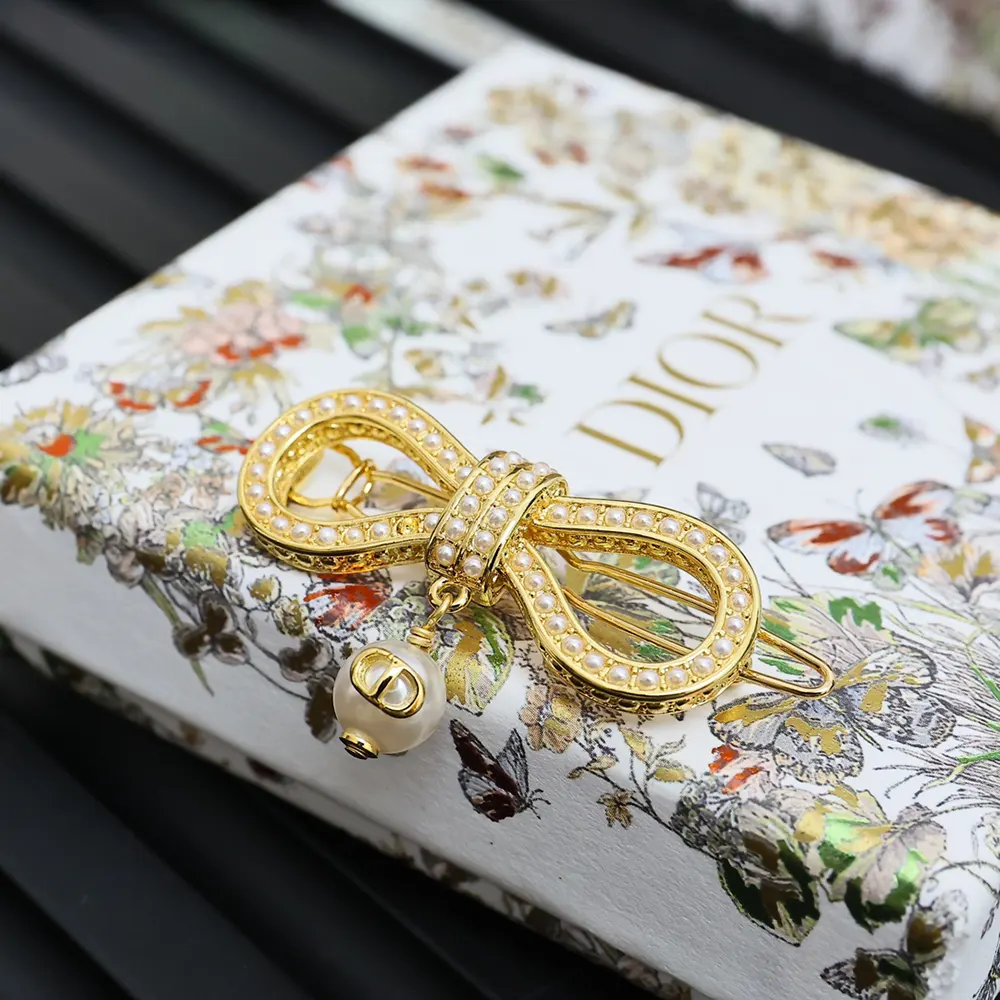 Styled hair featuring Dior Women Le Nœud de Dior Barrette gold finish detail