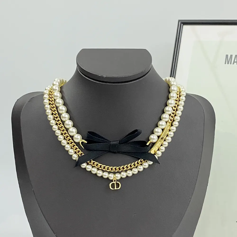 Close-up on white resin pearls and black satin bow of the choker
