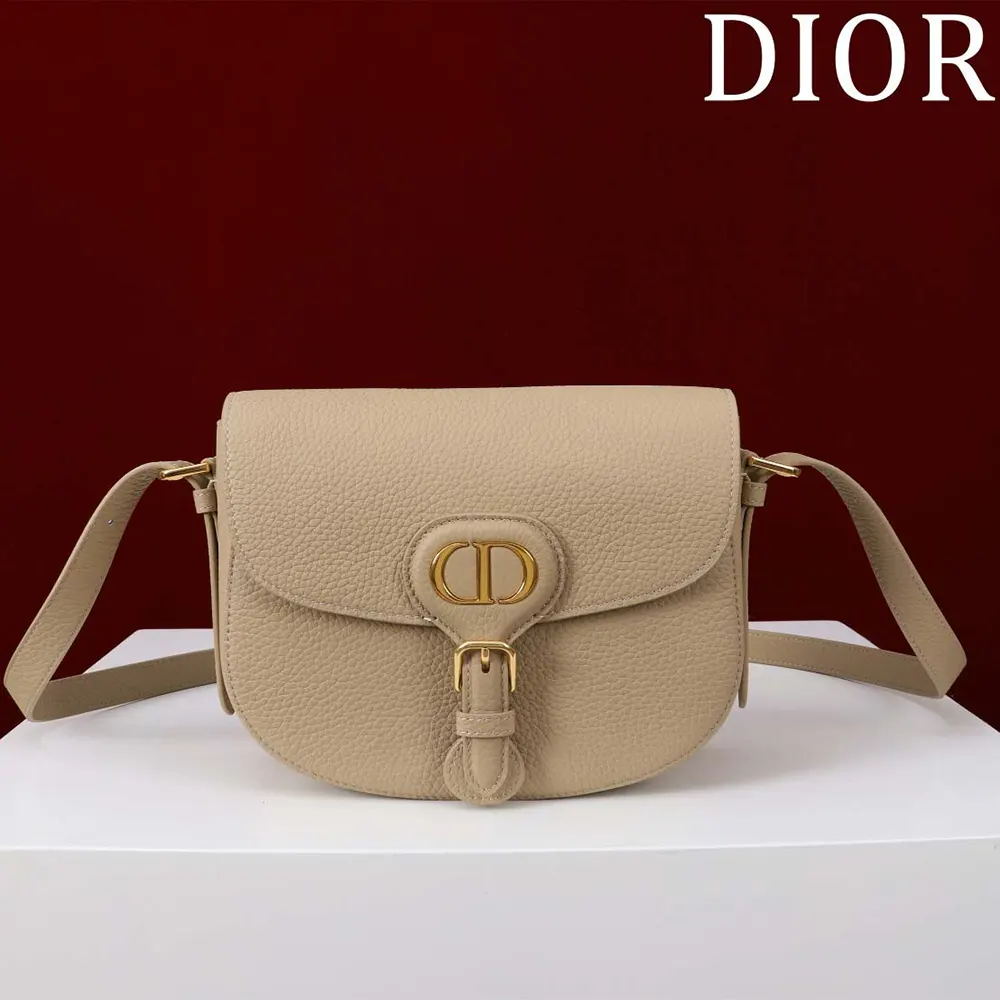 Close-up of antique gold ‘D’ hardware on Dior Women Medium Dior Bobby Bag Biscuit