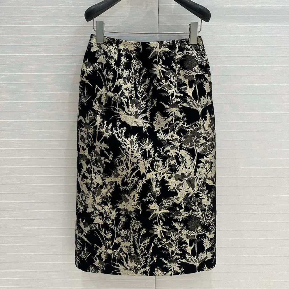 Close-up of gold-tone Dior Chardons motif on black skirt