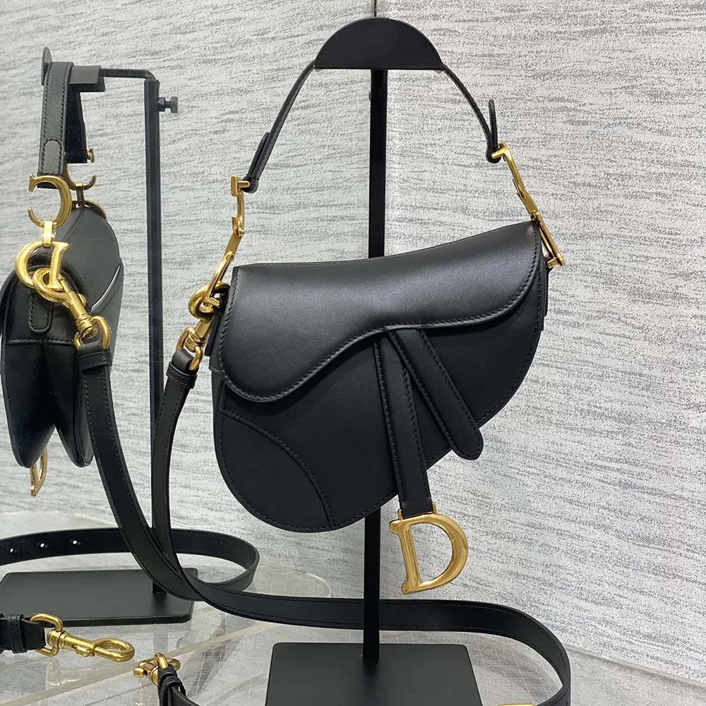 Close-up of silver-tone Dior 'D' hardware detail on mini saddle bag