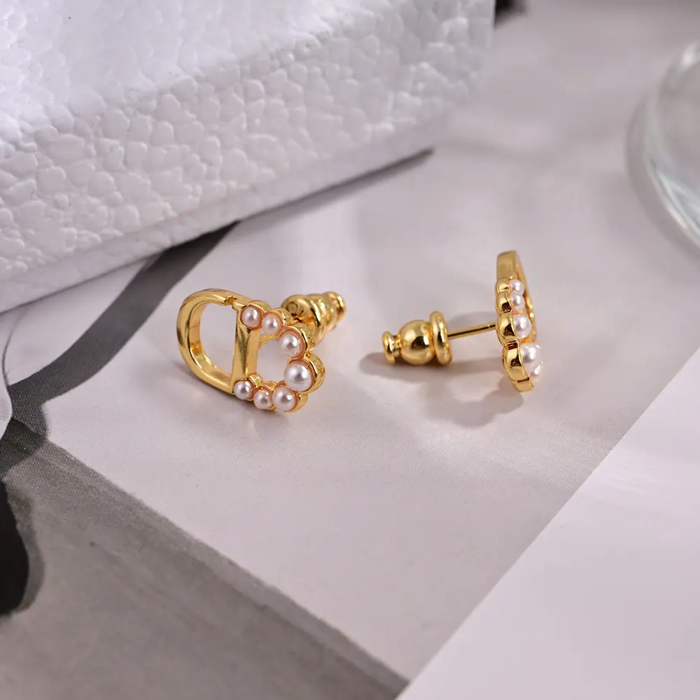 Side angle showing white resin pearls on Dior Women Petit CD Mini Stud Earrings