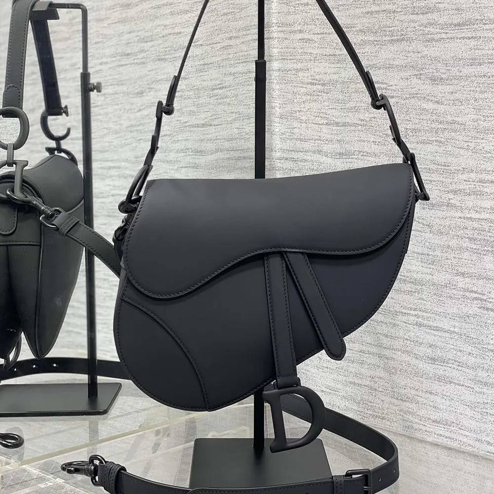 Close-up of signature 'D' charm on Dior Women Saddle Bag with Strap