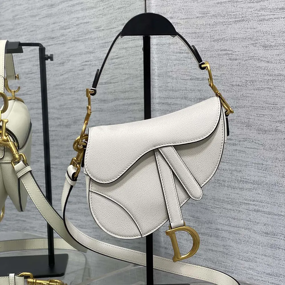 Close-up of gold-tone hardware and 'D' charm on Dior Women Saddle Bag