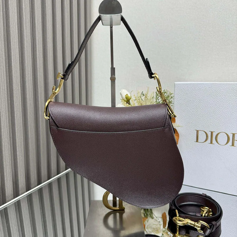 Side angle showing curved silhouette of Dior Women Saddle Bag with Strap Plum Grained Calfskin
