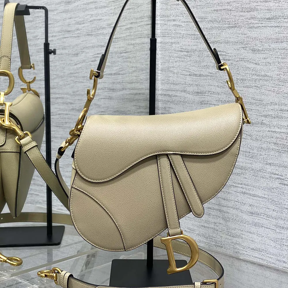 Close-up of gold-tone hardware and magnetic flap on sand-colored Dior bag