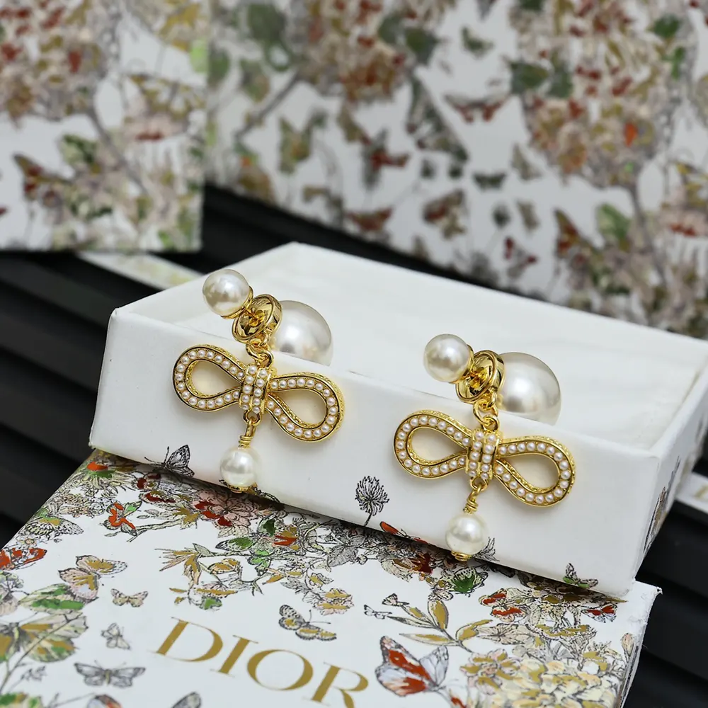 Close-up of champagne-finish metal and pearl detail on Dior Women Tribales Earrings