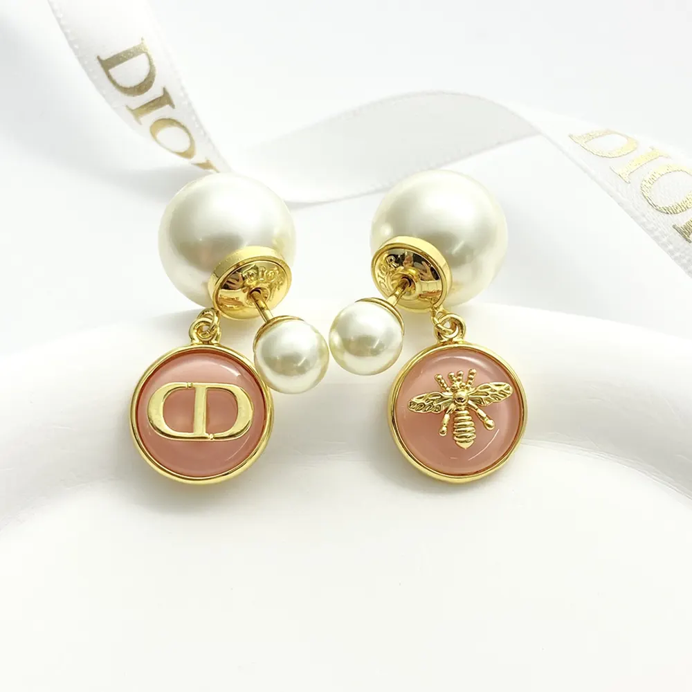 Side angle showing gold-finish metal and push-back closure on Dior Earrings