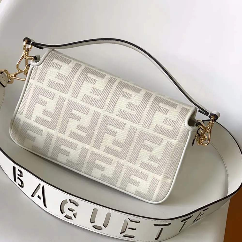 Side angle showing gold-tone hardware on Fendi white denim bag