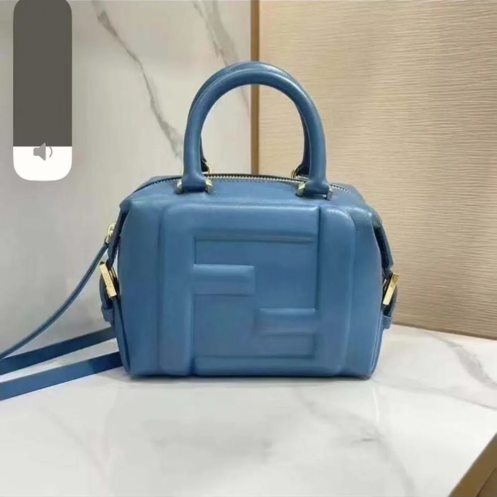 Close-up detail of Fendi FF gold-tone hardware on blue nappa leather