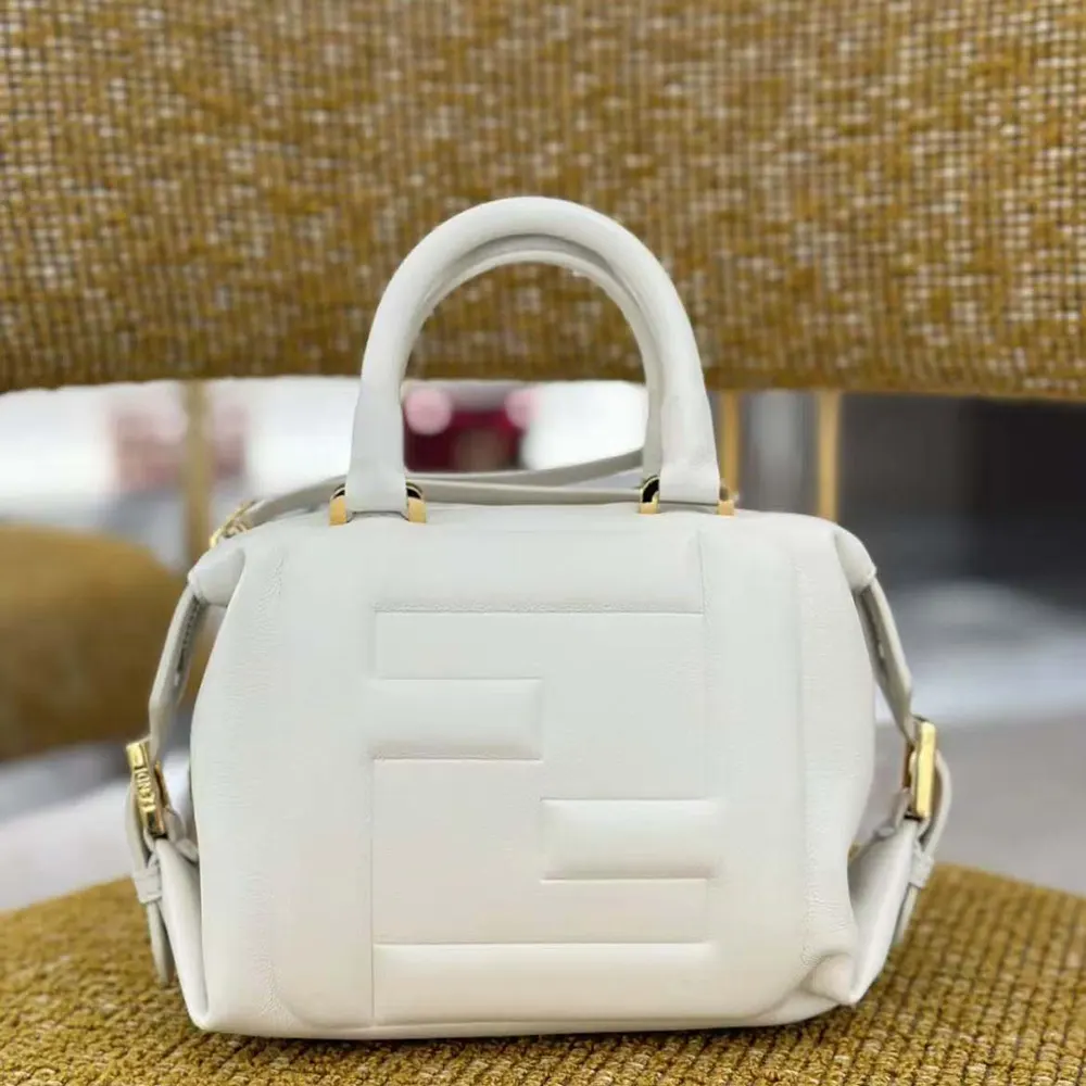 Close-up on gold-tone closure and white nappa leather texture detail