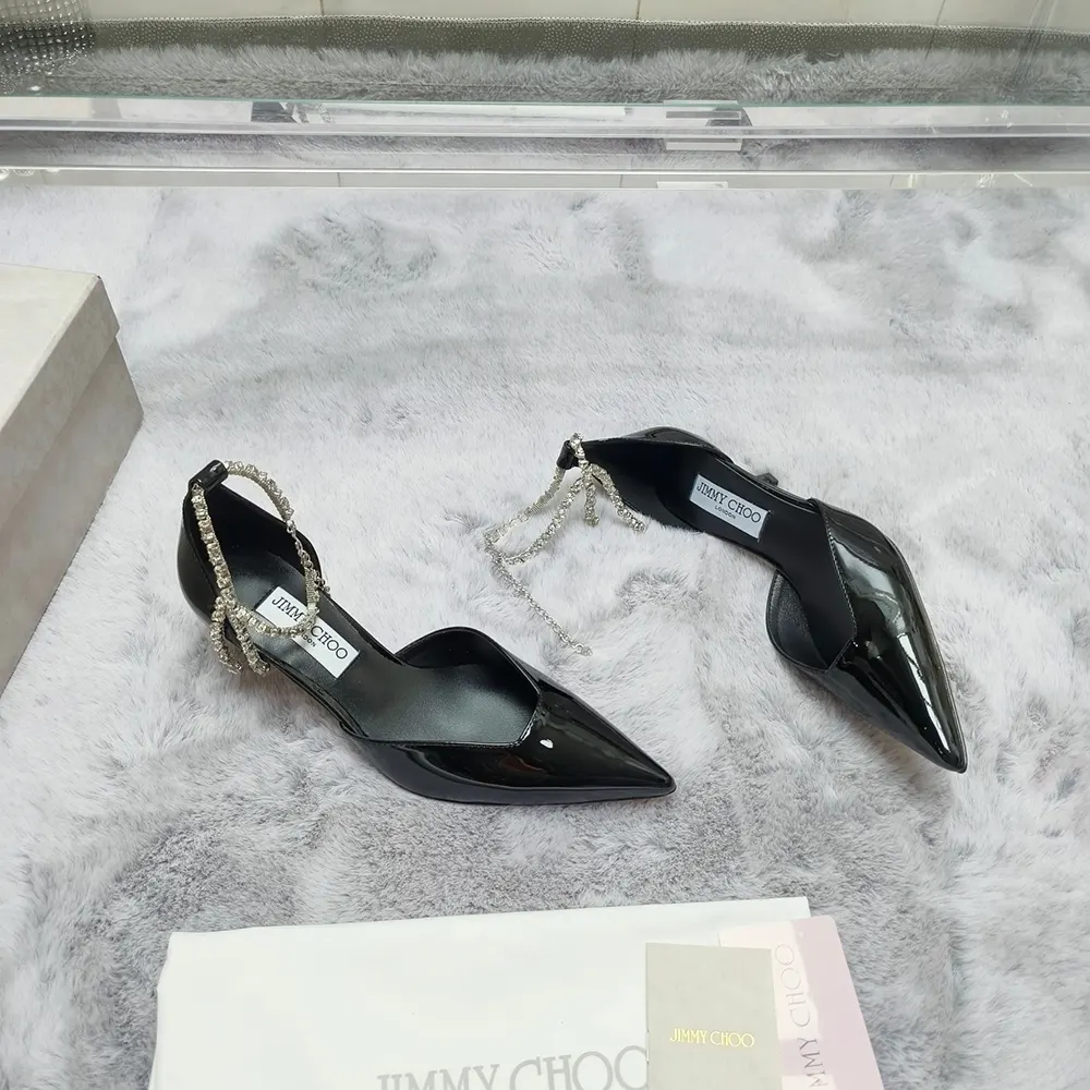 Close-up of glossy black patent leather and gold logo detail