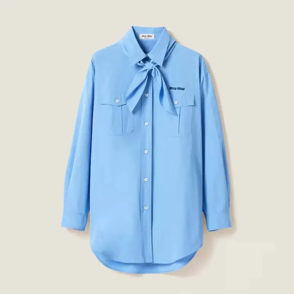 Close-up detail of scarf and button closure on Miu Miu shirt