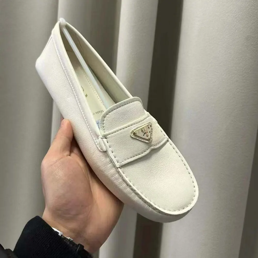 Close-up of premium white leather and embossed Prada logo detail