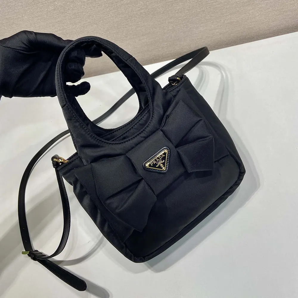 Side profile showing padded silhouette of Prada Women Padded Re-Nylon Mini-bag with Bow