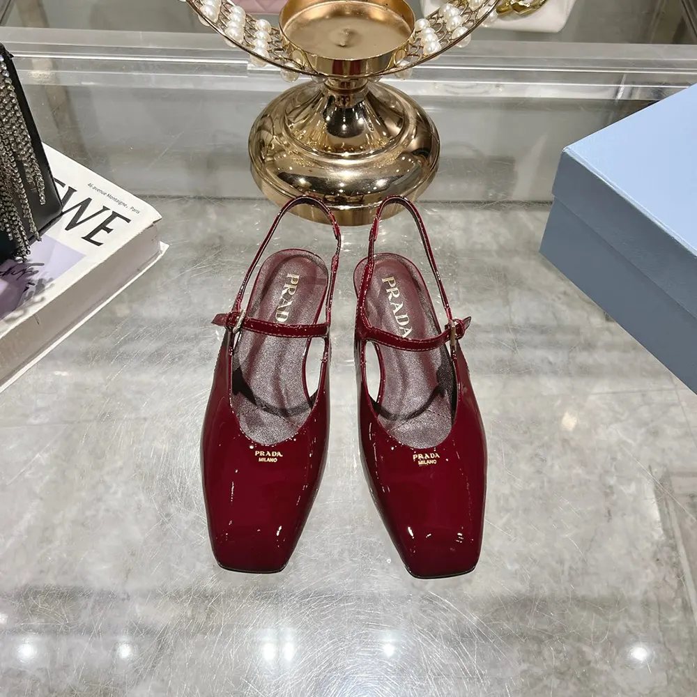 Close-up of Prada logo plaque on red patent leather slingback ballerinas