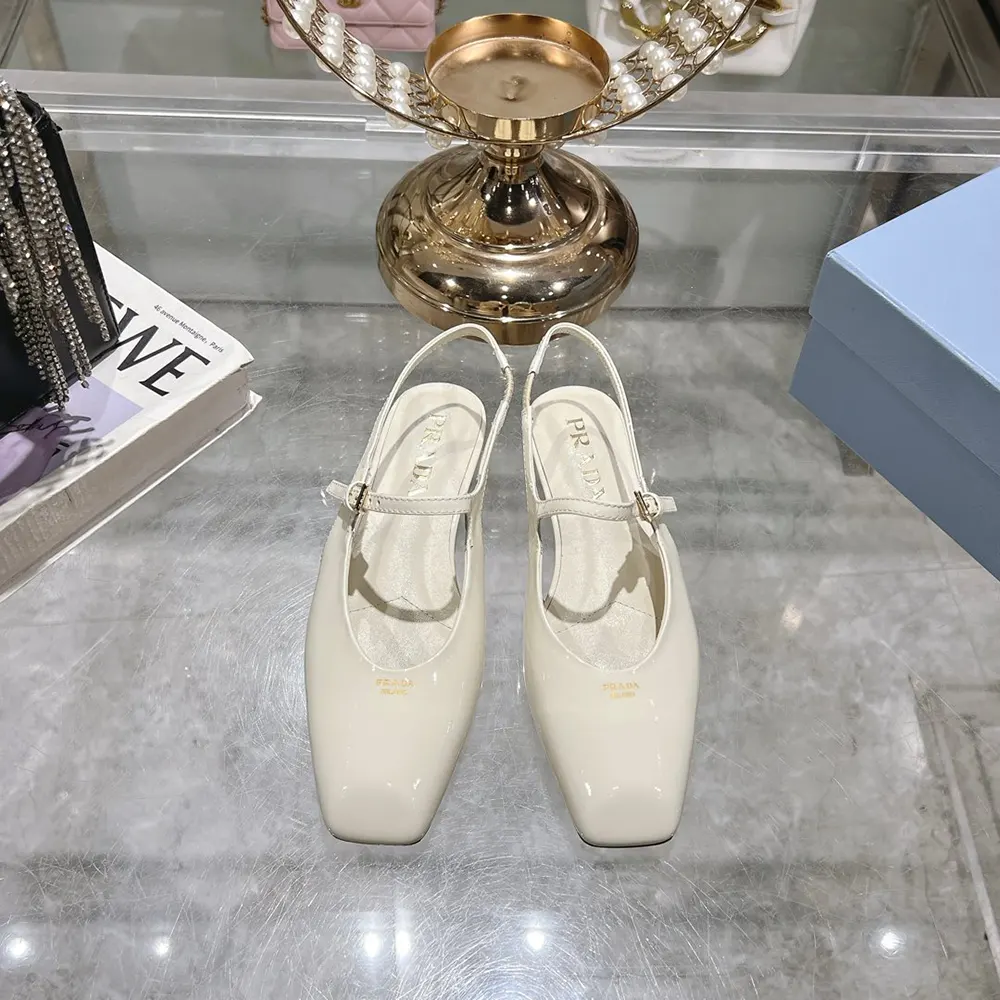 Close-up of slingback strap and silver Prada logo on white ballerinas