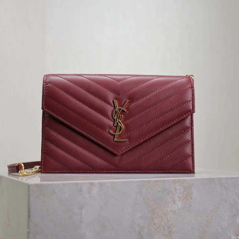 Close-up of gold YSL logo clasp and chain on Cassandre wallet
