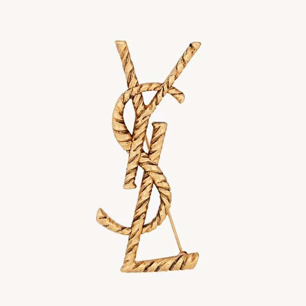 Close-up of Saint Laurent YSL Women Cassandre YSL Brooch in polished gold
