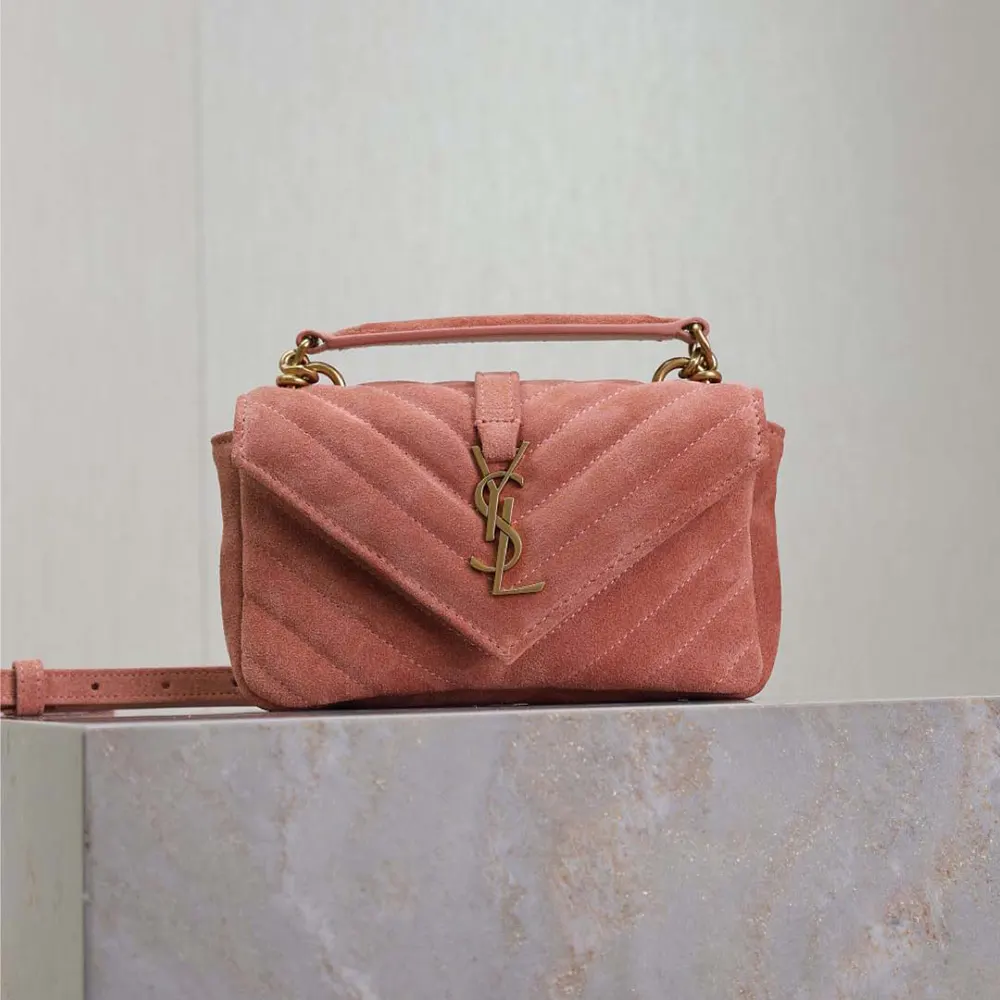 Close-up on gold YSL hardware on pink suede bag