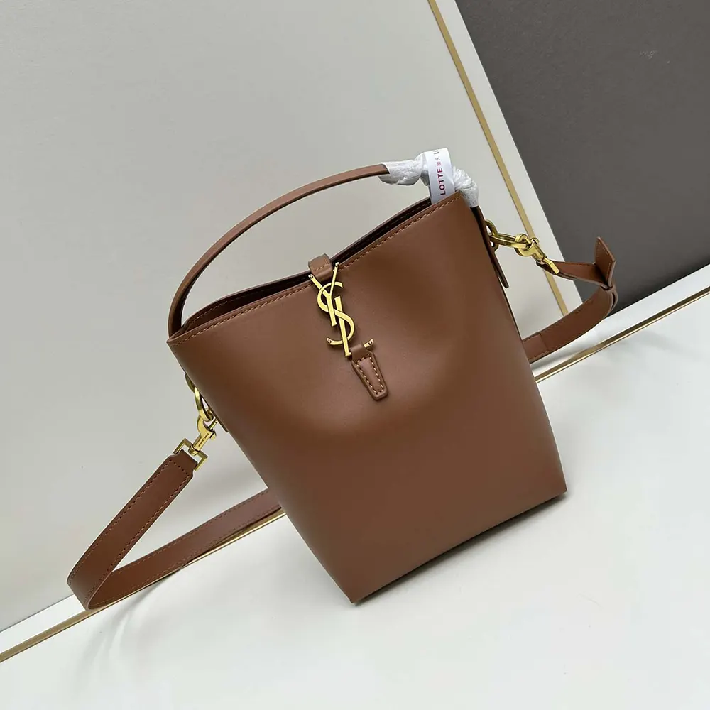 Close-up of gold YSL logo hardware on shiny leather bag