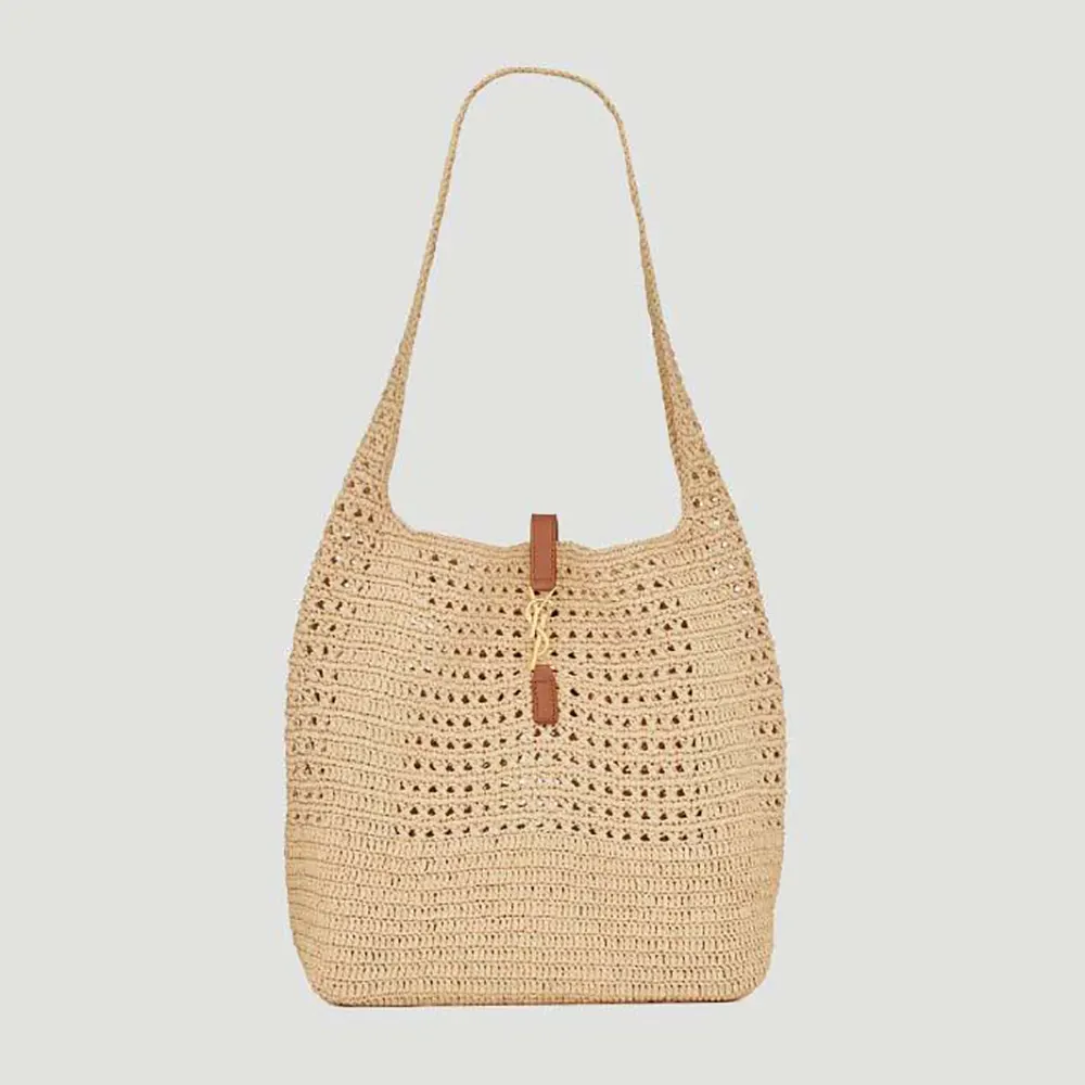 Close-up of gold YSL logo hardware on beige Saint Laurent shoulder bag