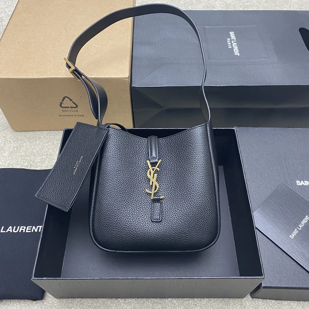 Close-up of gold-tone YSL hardware on black grained leather bag