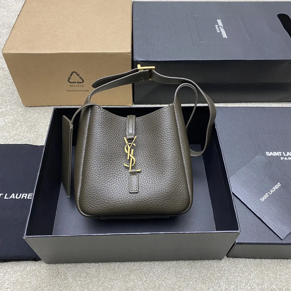 Close-up of gold YSL monogram hardware on dark green leather shoulder bag