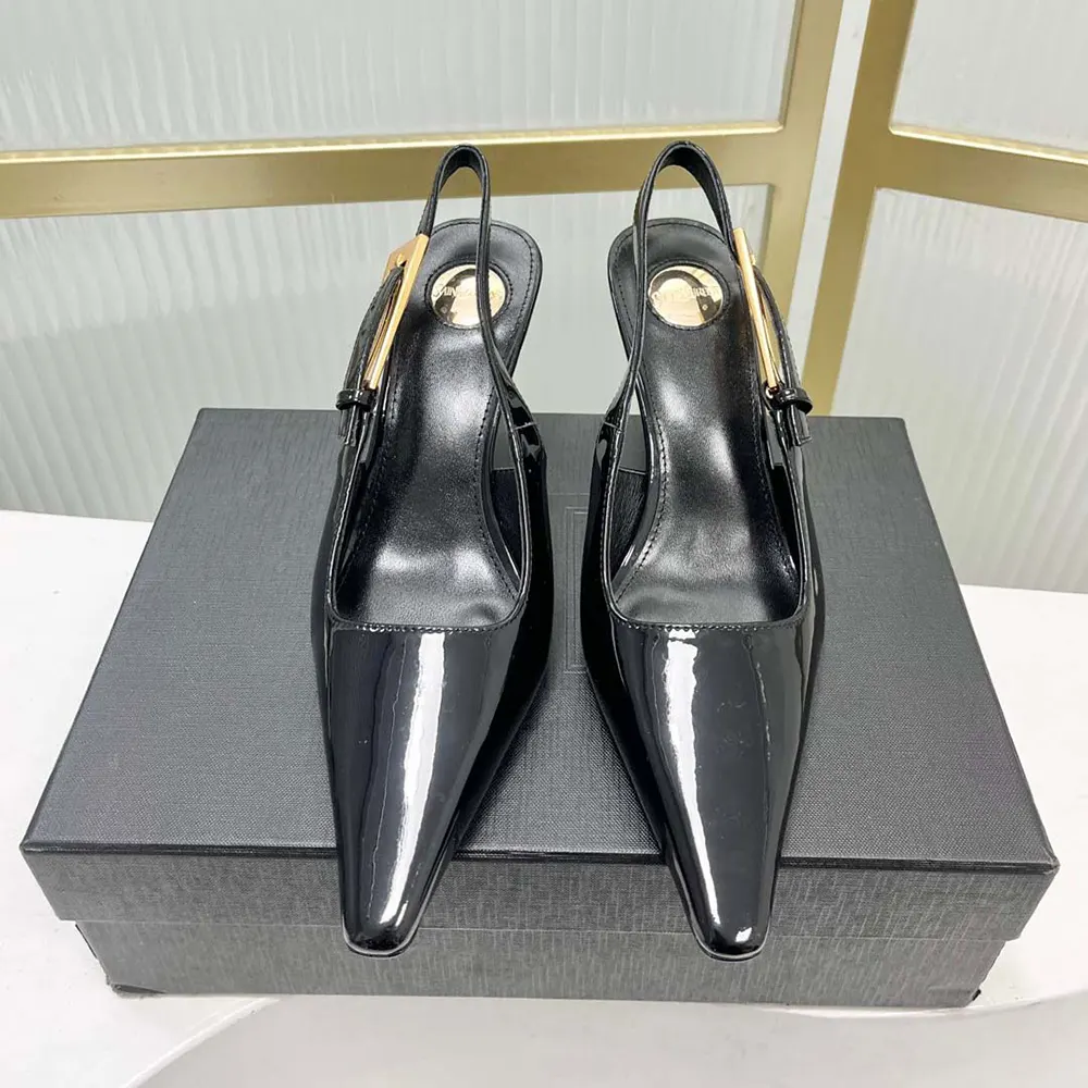 Close-up of gold YSL logo hardware on black glazed leather slingback pumps