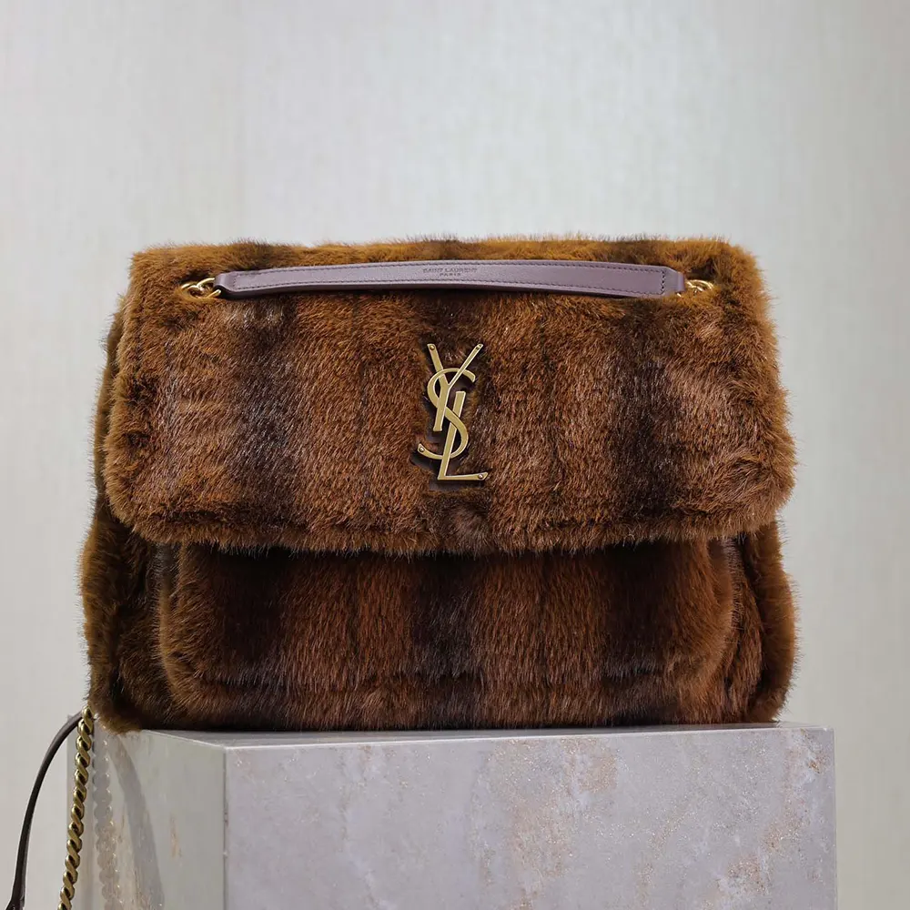 Close-up of antique gold YSL logo on Saint Laurent YSL Women Niki Large in Shearling