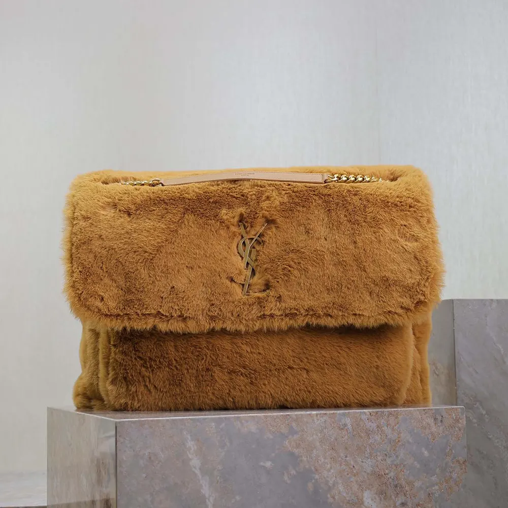 Close-up of gold YSL hardware on brown feather-trimmed bag