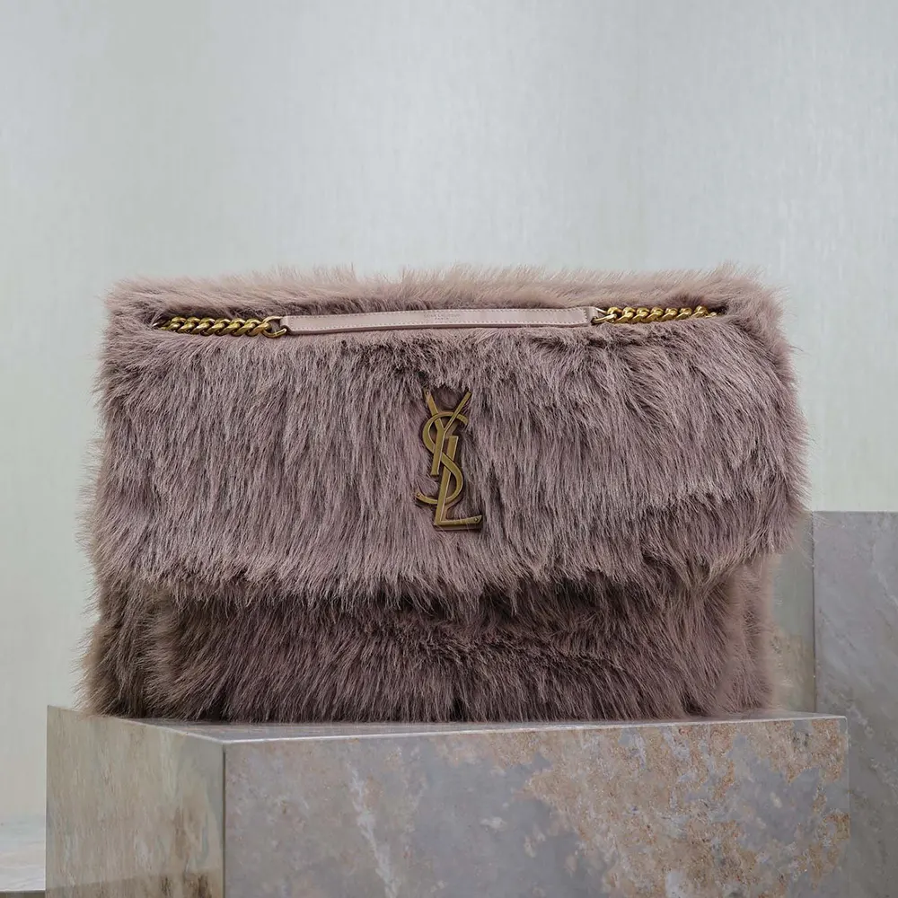 Close-up on gold YSL logo hardware of Oversized Niki in Feathers