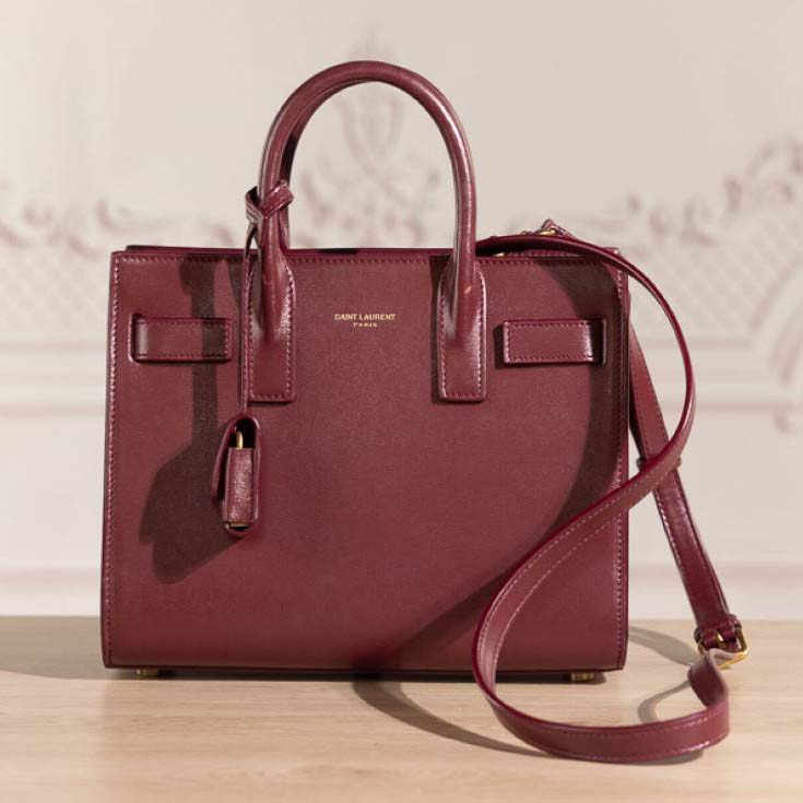 Close-up on gold YSL hardware and burgundy smooth leather texture